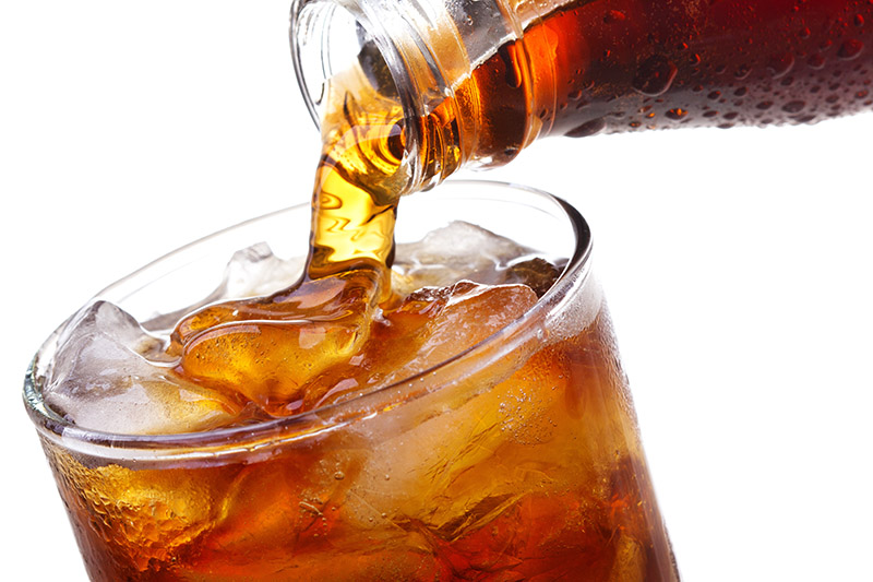 Cola hölls upp i ett glas med is